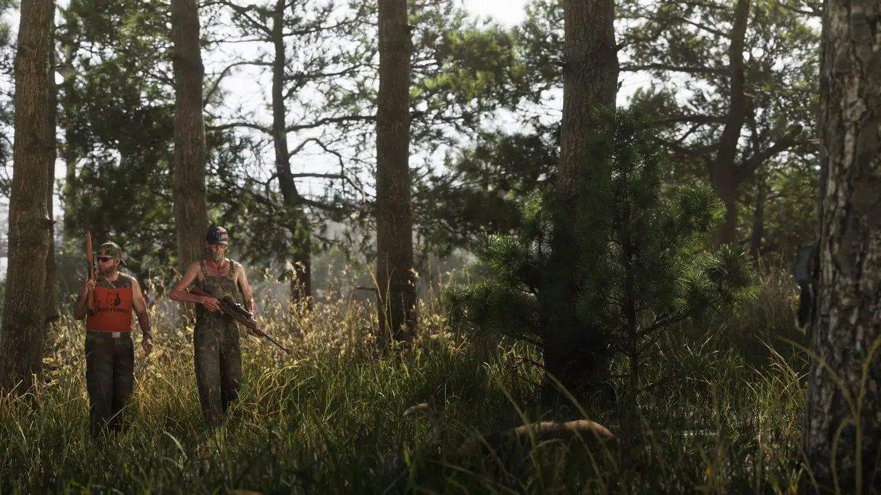 Two people holding rifles walking side by side through the woods of Mount Kalaga National Park.