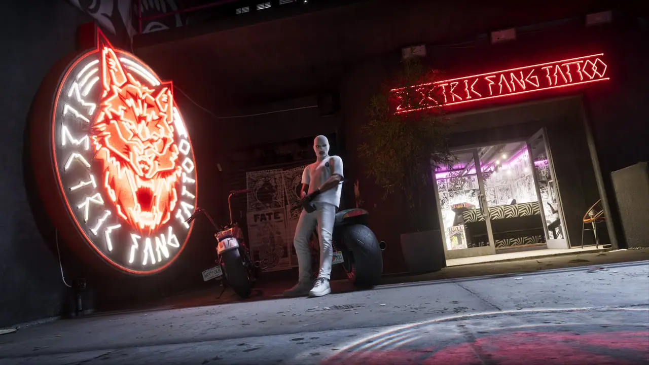 The large neon wolf sign outside Electric Fang Tattoo at night, with a man standing beside a motorcycle in front of the shop.