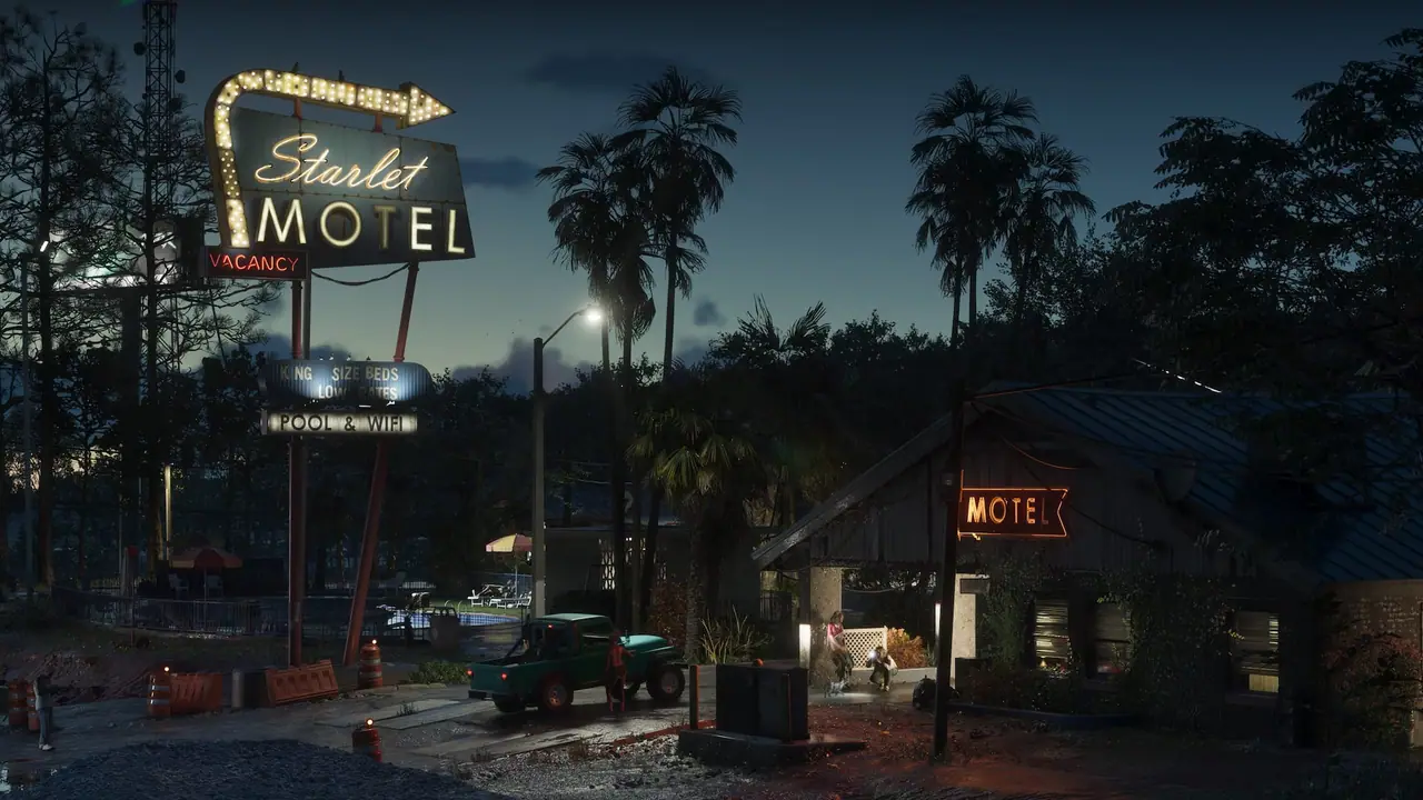 The outside of a motel in Port Gellhorn with the vacancy sign lit up at night.